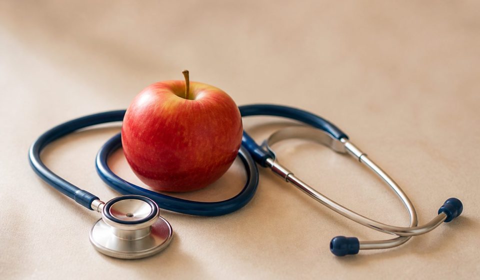 Stethoscope resting beside a red apple - illustration for Heart Disease: When to Get Checked at a Clinic