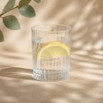Glass of water with lemon slice on table - illustration for How dehydration affects focus and physical performance
