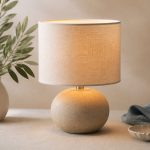 Lamp casting warm light on bedroom table - illustration for How indoor lighting affects your comfort and sleep quality