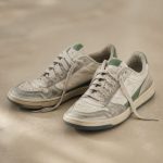 Pair of worn-out sneakers on floor - illustration for How standing too long impacts your body and how to move healthy
