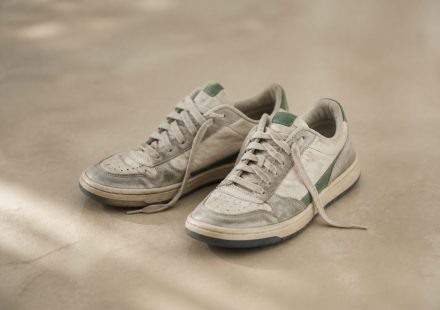 Pair of worn-out sneakers on floor - illustration for How standing too long impacts your body and how to move healthy