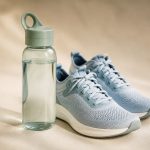 Water bottle beside fresh running shoes on floor - illustration for How your body adjusts to new routines and healthy habits