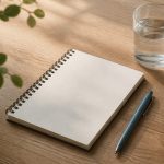 Notepad pen water glass on wooden table - illustration for How to Prepare for Your Medical Appointment