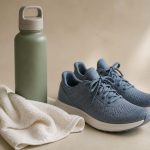 Water bottle towel and running shoes on floor - illustration for Why listening to your body during exercise boosts your health