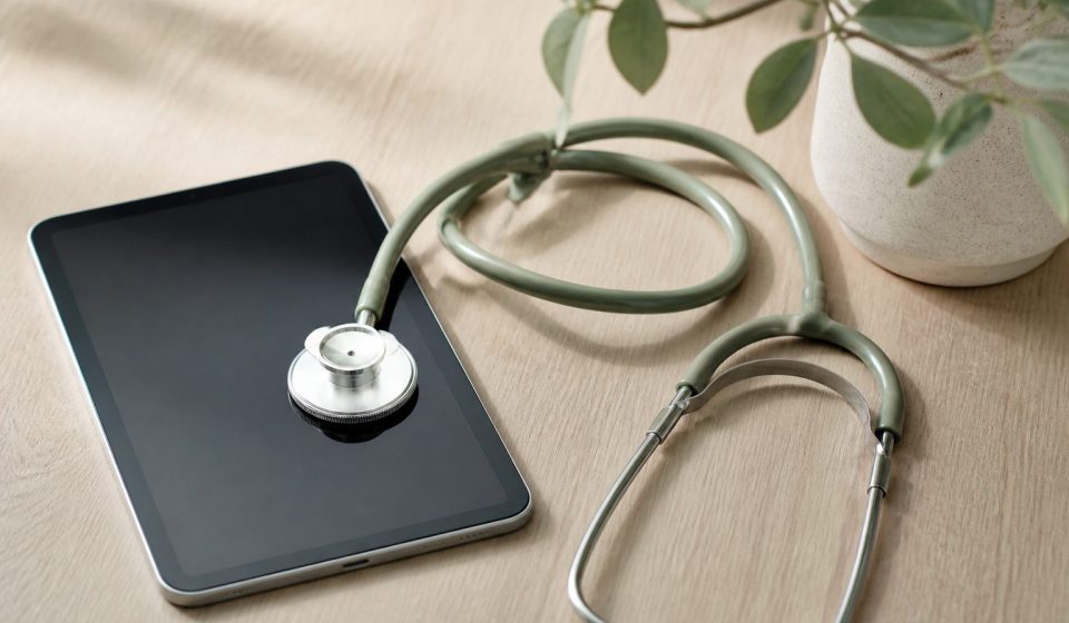 Stethoscope and digital tablet on wooden table - illustration for How modern medical technology is improving patient care and outcomes