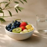 Bowl of fresh fruit and glass of water - illustration for The Connection Between Gut Health and Overall Wellness