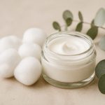 Jar of soothing cream beside cotton balls - illustration for Understanding eczema symptoms and how to manage them for healthy skin