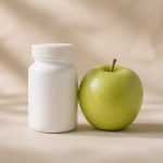 White pill bottle next to fresh green apple - illustration for Understanding Preventive Medicine and Its Benefits