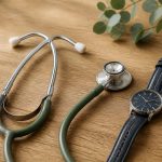 Stethoscope and wristwatch on wooden table - illustration for Why Every Adult Should Schedule Regular Health Assessments: The Key to Preventive Healthcare and Long-Term Wellness