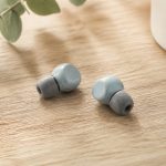 Earbuds with foam ear tips on wooden table - illustration for Why hearing health matters at every age and how to protect it