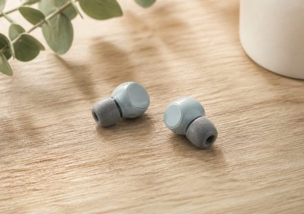 Earbuds with foam ear tips on wooden table - illustration for Why hearing health matters at every age and how to protect it