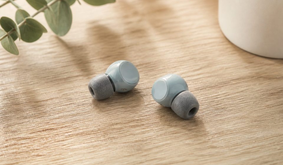 Earbuds with foam ear tips on wooden table - illustration for Why hearing health matters at every age and how to protect it