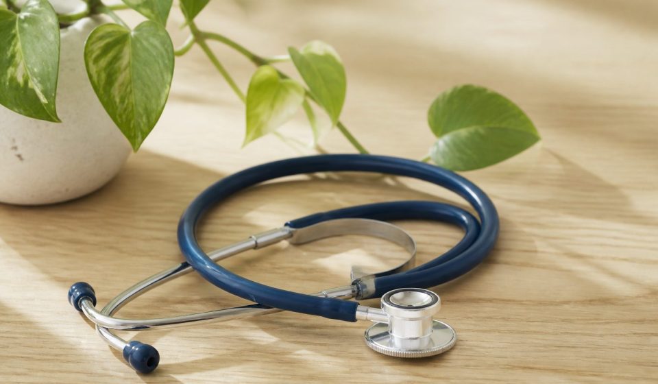 Stethoscope on a wooden desk with plant - illustration for Why Patient-Centered Care Is Shaping the Future of Healthcare: The Key to Better Outcomes and Personalized Treatment